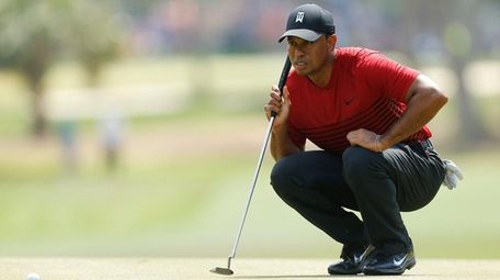 Tiger Woods looks over a putt on