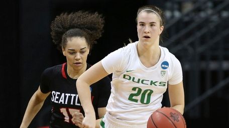 Oregon's Sabrina Ionescu, right, brings the ball down