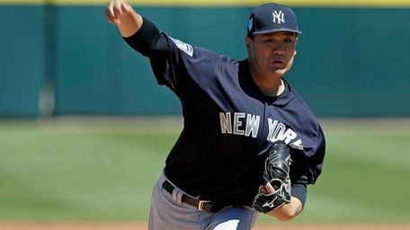 Yankees pitcher Masahiro Tanaka throws in the first