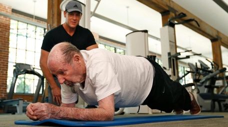Ray Bagley, 96, holds a plank during a