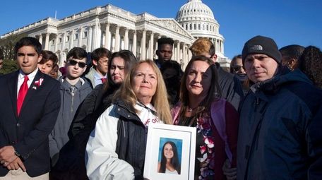 Terri Robinowitz, center, holds a framed photo of