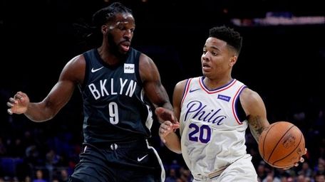 The 76ers' Markelle Fultz, right, drives to the