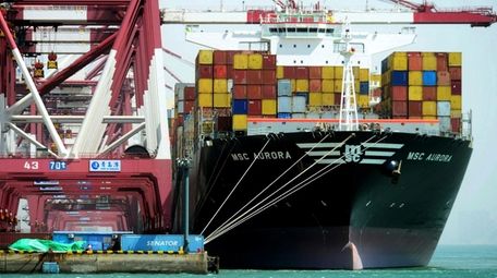 Containers are loaded onto a cargo ship at