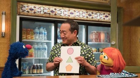 Julia, right, is a muppet with autism on
