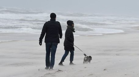 A couple walk their dog at Smith Point