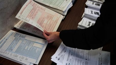 A woman picks up tax forms in the