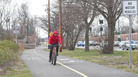 A cyclist uses the paved path built alongside