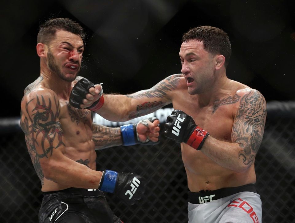 Frankie Edgar, right, hits Cub Swanson during the