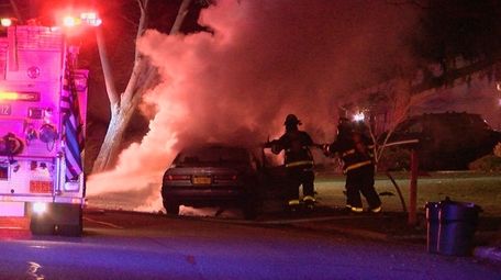 Firefighters work at the scene where a car