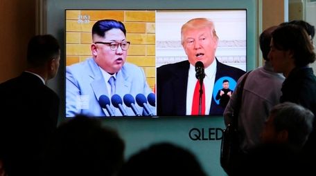 People watch a television screen showing North Korean