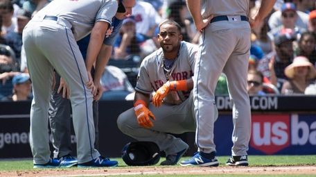The Mets' Yoenis Cespedes (center) gets his injured