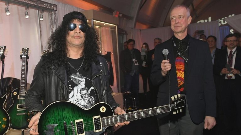 Recording artist Slash, left, is presented a one
