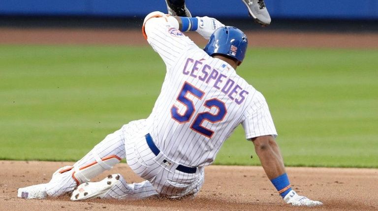 The Mets' Yoenis Cespedes slides under Braves second baseman