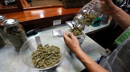 An employee prepares marijuana for sale at The