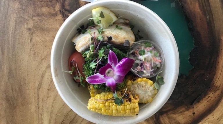 Grilled mahi mahi with side dishes of corn,
