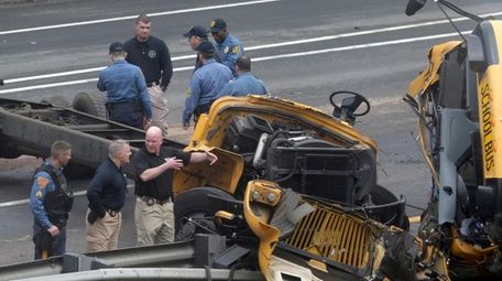 Emergency personnel examine a school bus after it