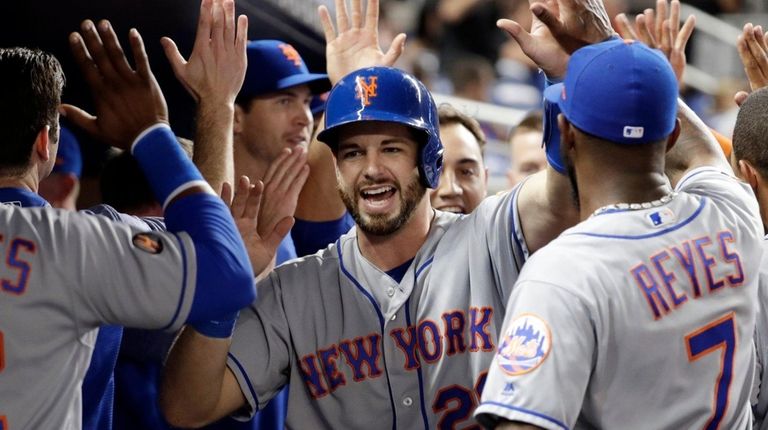 Mets catcher Kevin Plawecki is congratulated after scoring