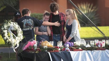 Students mourn at a community dinner on May