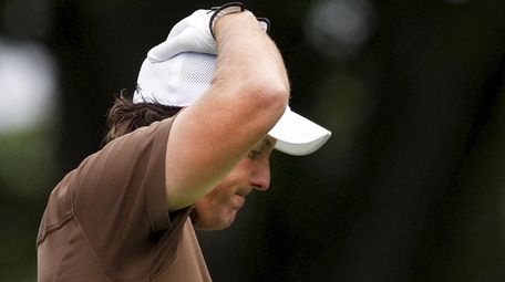 Phil Mickelson reacts to his tee shot on