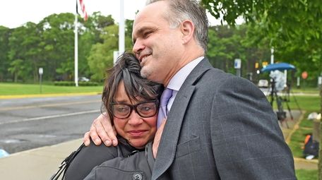 Linda Mangano, embraces her attorney John Carman, outside