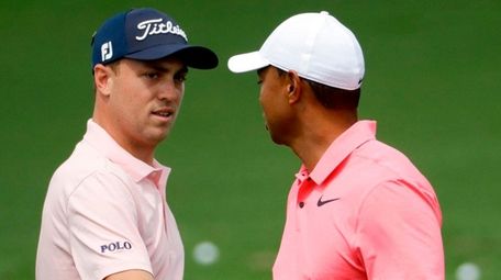 Tiger Woods, right, greets Justin Thomas on the