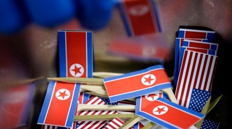 Miniature American and North Korean flags are piled