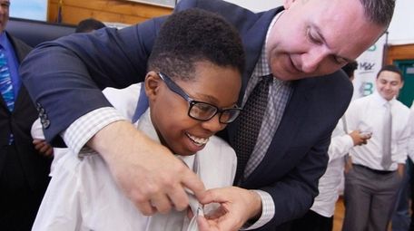 Allan Belizarre, 14, of Brentwood, gets his tie