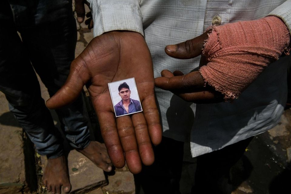 A man shows a photo of Gautam Singh,