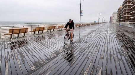 A lone biker rides along the boardwalk on