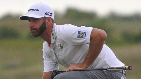 Dustin Johnson reads the greens on the 17th