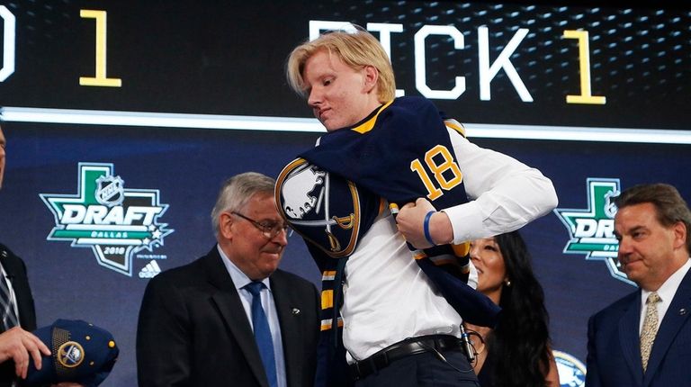 Rasmus Dahlin puts on a jersey after being
