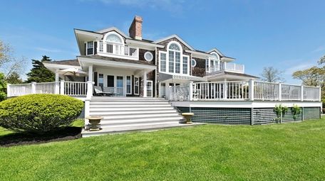 The six-bedroom, shingled house has a wraparound porch,