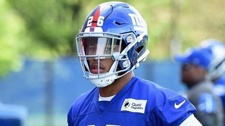 Giants running back Saquon Barkley looks on from