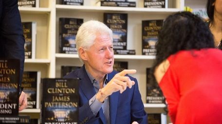 Former President Bill Clinton signs copies of his
