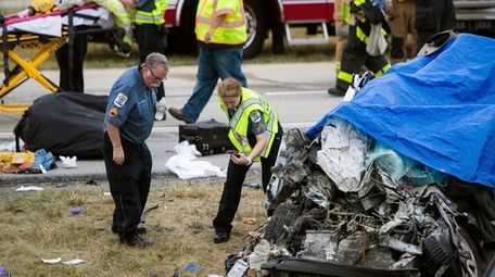 Paramedics work the scene of a deadly car