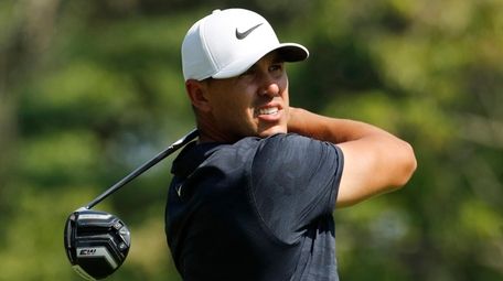 Brooks Koepka watches his shot from the fourth