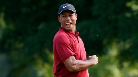 Tiger Woods celebrates after making a birdie putt