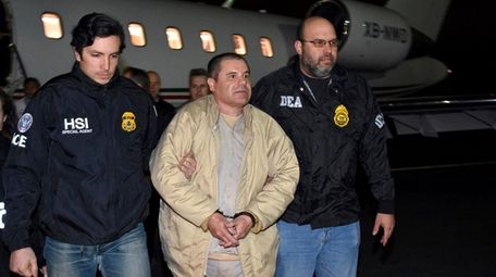 Authorities escort Joaquin "El Chapo" Guzman, center, from