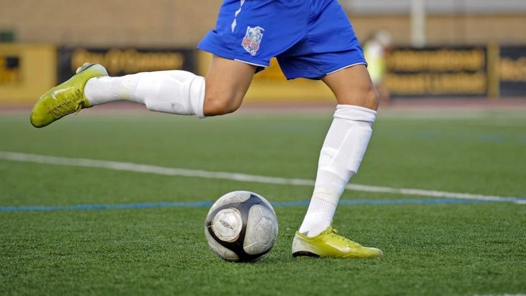A Rough Rider kicks the soccer ball in