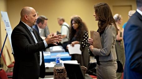 A company representative, left, speaks with a job