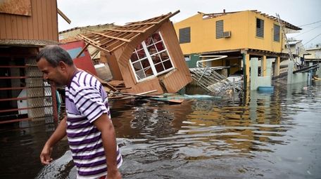A man walks past destroyed homes in Cataño,