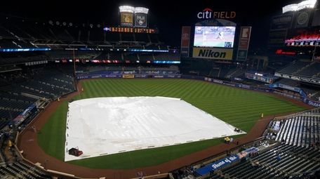 The tarp is seen on the field during