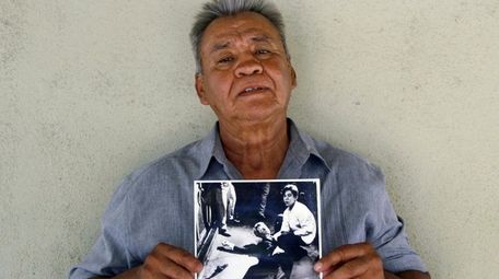 Juan Romero holding a Los Angeles Times photograph