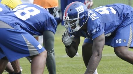 Giants linebacker Adrian Tracy, left, and defensive end