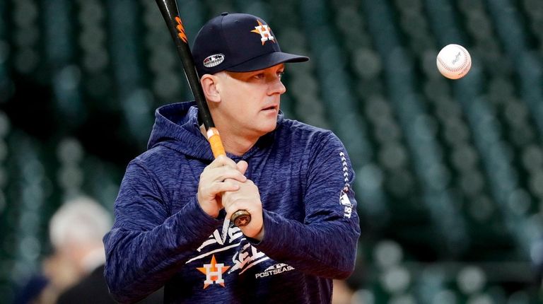 Astros manager AJ Hinch hits during batting practice
