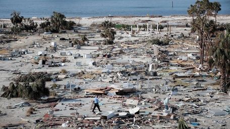 A man walks through a beachfront neighborhood that