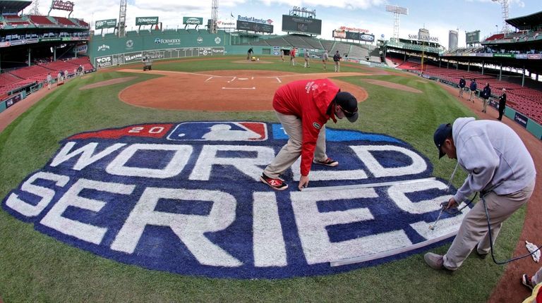 Grounds crew members paint the World Series logo