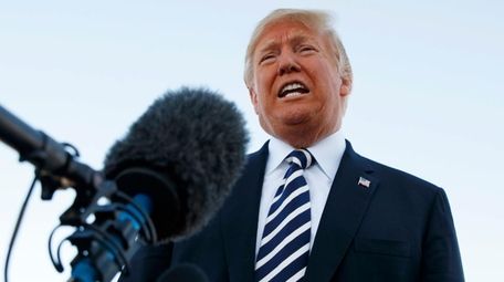 President Donald Trump speaks to media before boarding