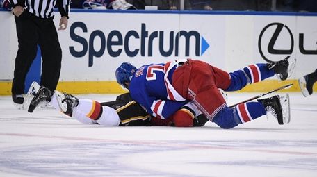 Rangers defenseman Brady Skjei tackles Flames defenseman Rasmus