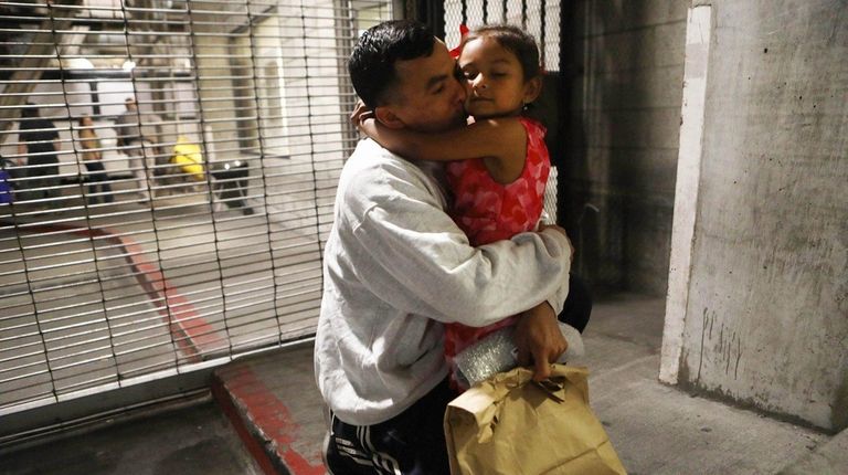 Honduran father Victor hugs his daughter Katie outside